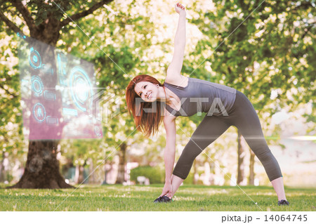 Composite image of pretty athletic redhead stretching in park 14064745