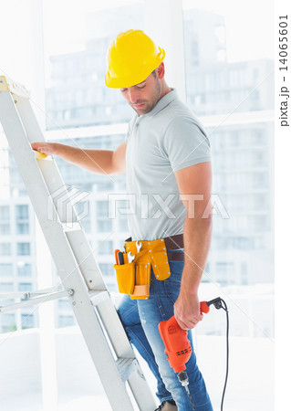 Manual worker with drill machine climbing ladder Manual worker with drill machine climbing ladder 14065601
