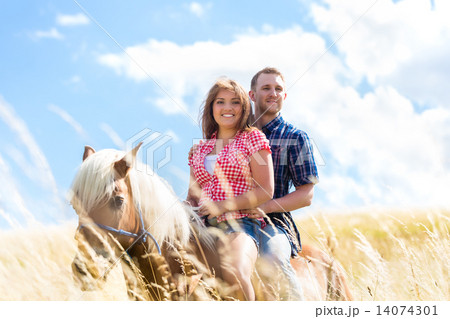 Couple riding on horse in summer meadow 14074301