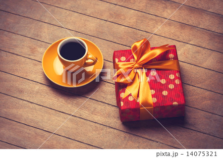 Cup of coffee and gift box on a wooden table. Cup of coffee and gift box on a wooden table. 14075321