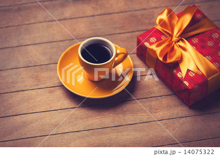 Cup of coffee and gift box on a wooden table. Cup of coffee and gift box on a wooden table. 14075322