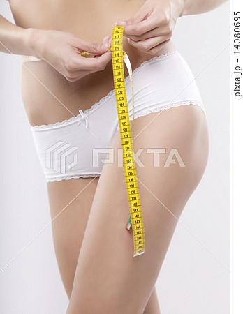 Beautiful sporty woman with yellow measure around body 14080695