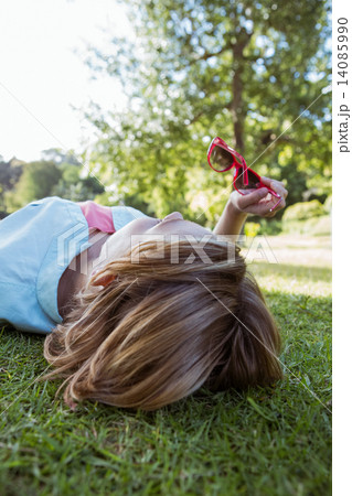 Pretty woman lying down in park Pretty woman lying down in park 14085990