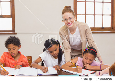 Cute pupils getting help from teacher in classroom Cute pupils getting help from teacher in classroom 14086090