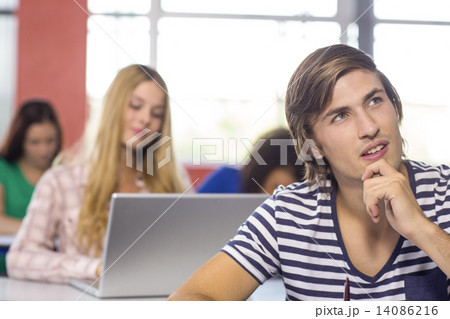 Thoughtful male student in classroom Thoughtful male student in classroom 14086216