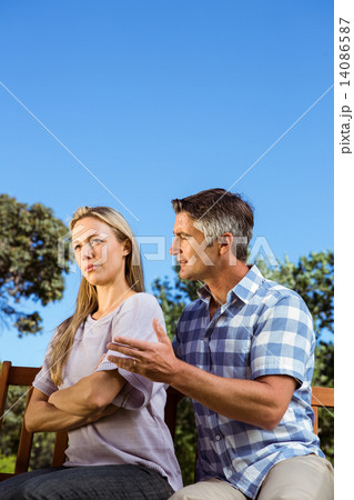 Couple having an argument on park bench 14086587