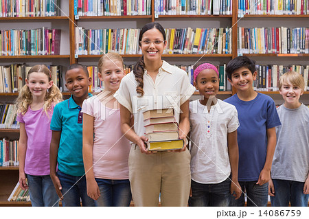 Cute pupils and teacher having class in library Cute pupils and teacher having class in library 14086759