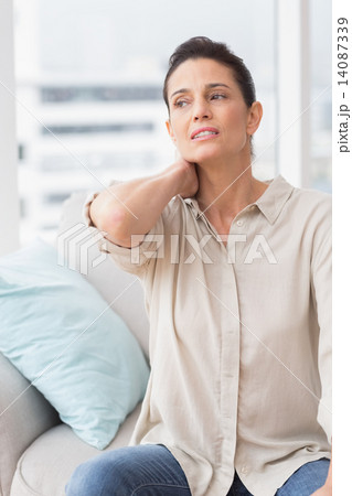 Upset woman suffering from backache at home Upset woman suffering from backache at home 14087339