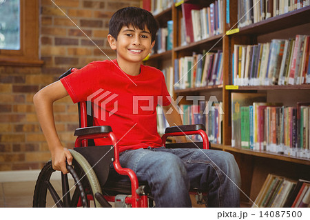 Portrait of boy sitting in wheelchair at library 14087500
