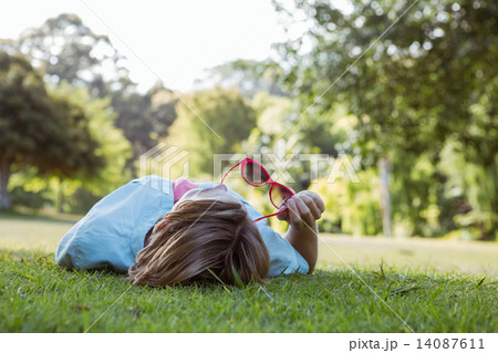Pretty woman lying down in park 14087611