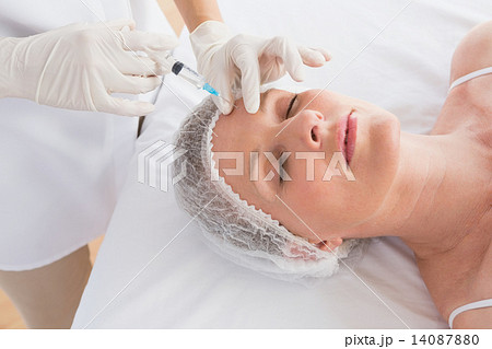 Woman receiving botox injection on her forehead Woman receiving botox injection on her forehead 14087880