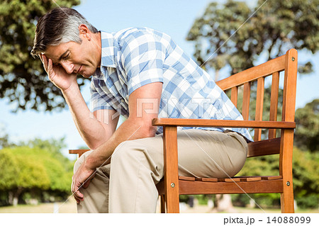 Upset man sitting on park bench Upset man sitting on park bench 14088099