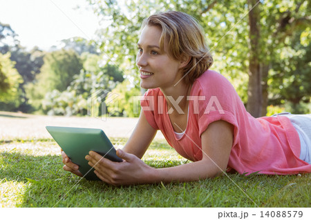 Pretty woman using tablet in park Pretty woman using tablet in park 14088579