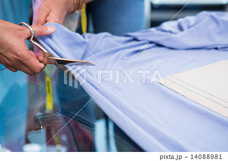 Hands cutting fabric at table Hands cutting fabric at table 14088981