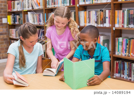 Cute pupils reading in library Cute pupils reading in library 14089194