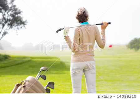Lady golfer holding her club behind her head 14089219