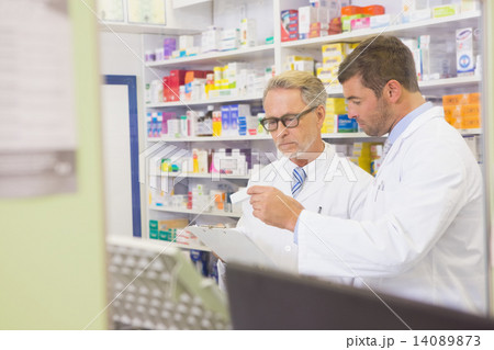 Senior pharmacist reading a prescription on clipboard 14089873