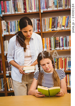 Teacher and girl reading book in library Teacher and girl reading book in library 14090184