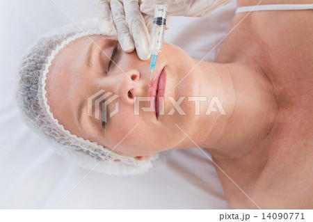 Woman receiving botox injection on her lips Woman receiving botox injection on her lips 14090771