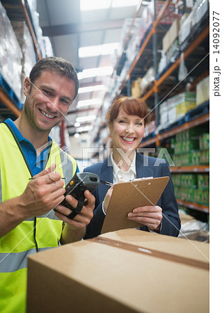 Worker and manager scanning package in warehouse 14092077
