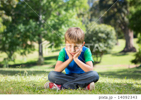 Little boy feeling sad in the park Little boy feeling sad in the park 14092343
