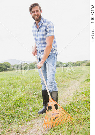 Happy man raking his farm Happy man raking his farm 14093152