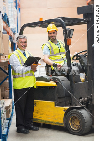 Driver operating forklift machine next to his manager 14093208