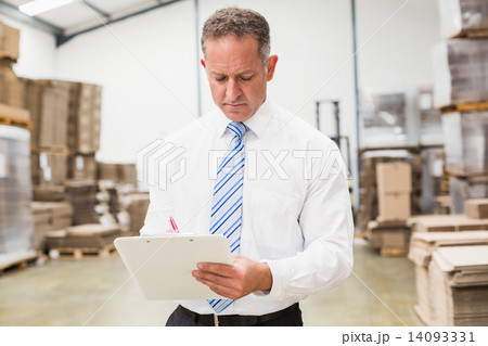Serious boss writing on clipboard Serious boss writing on clipboard 14093331