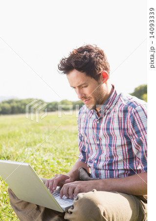 Young man using laptop in the countryside 14093339