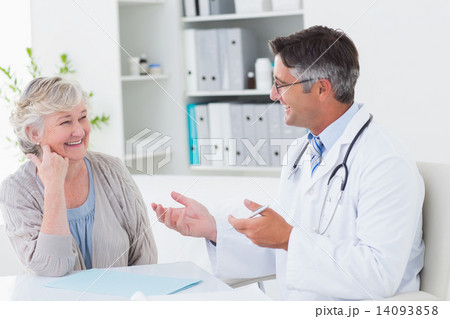 Doctor discussing with senior patient at table Doctor discussing with senior patient at table 14093858
