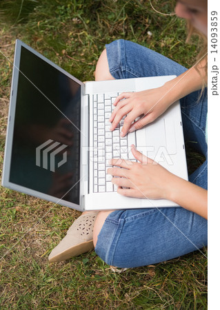 Woman using laptop in park Woman using laptop in park 14093859