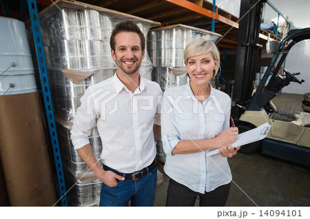 Smiling warehouse managers looking at camera Smiling warehouse managers looking at camera 14094101