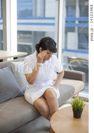 An Asian stressed nurse sitting at the rest area. An Asian stressed nurse sitting at the rest area. 14103968