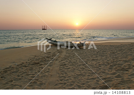 boat on the ocean shore at sunset. Kerala, India 14108813
