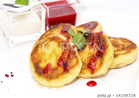 cheesecakes with sour cream and jam on table in restaurant cheesecakes with sour cream and jam on table in restaurant 14109728