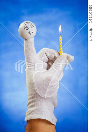 Burning birthday candle hold by finger puppet Burning birthday candle hold by finger puppet 14110609