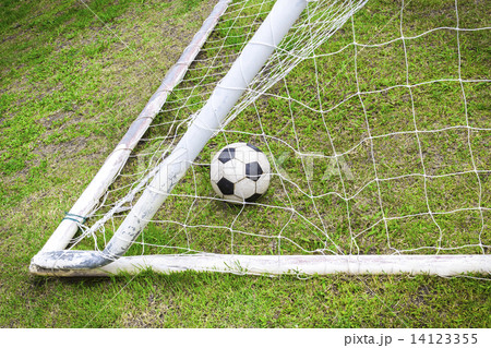 Old soccer ball in old goal net Old soccer ball in old goal net 14123355