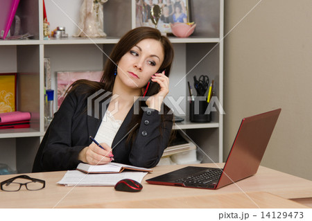 girl at desk prepared to write in a notebook information obtained from telephone conversation girl at desk prepared to write in a notebook information obtained from telephone conversation 14129473