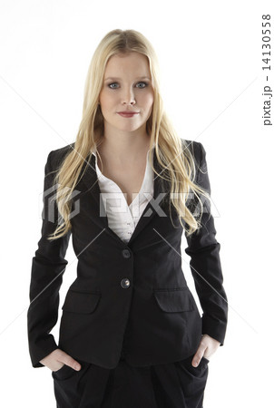 Portrait of a business woman with hands in pockets standing against white background 14130558