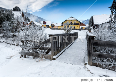 small wooden bridge over mountain river in Alps at snowy day small wooden bridge over mountain river in Alps at snowy day 14139800