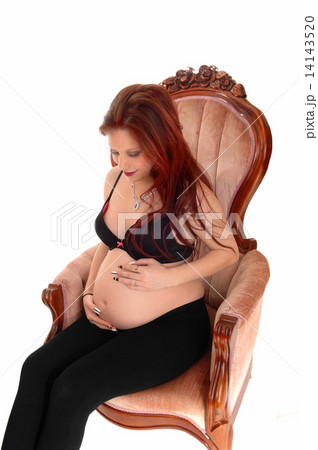 Pregnant woman in armchair. 14143520