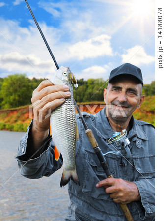 chub in the hand of fisherman against the sky and the river 14188078