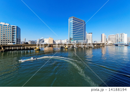 運河を航行中の漁船と高層ビル群 14188194