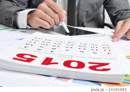 man in suit using a tablet and a 2015 calendar 14191003