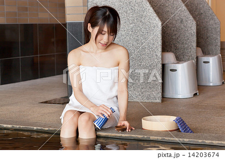 温泉に入りお酒を楽しむ若い女性 14203674