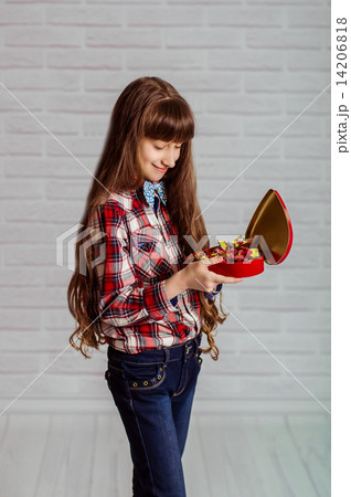Little girl with a red box of chocolates in a heart shape Little girl with a red box of chocolates in a heart shape 14206818