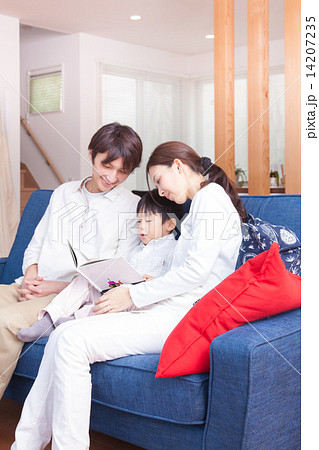 新しい家のリビングで絵本を読む家族 14207235