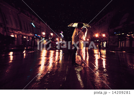 Love in the rain / Silhouette of kissing couple under umbrella 14209281