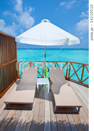 Parasol and chaise lounges on a terrace of water villa, Maldives. 14210510