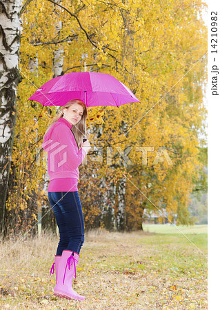 woman wearing rubber boots with umbrella in autumnal nature 14210982